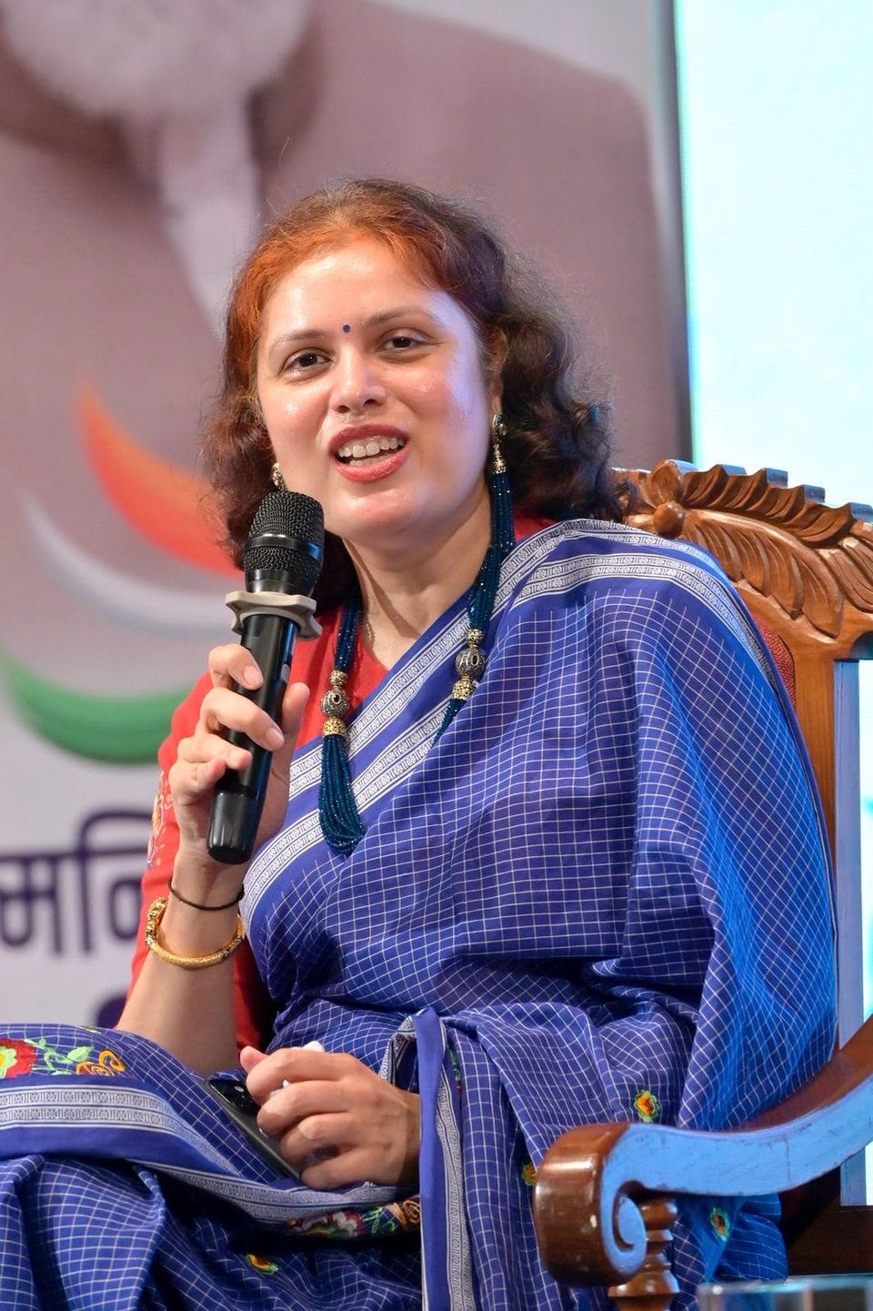 Pallavi Salgaocar speaking into a microphone at an industry event.